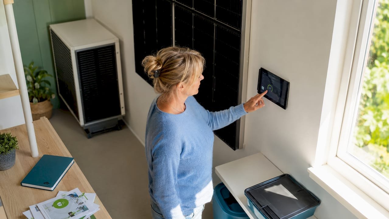 Een vrouw stelt handig het energiepaneel in bij haar thuis