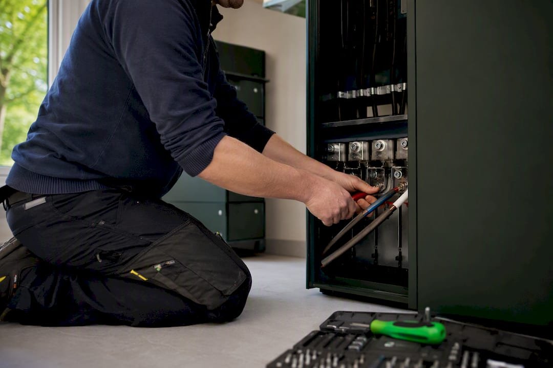 Handen die een driefasige thuisbatterij aansluiten