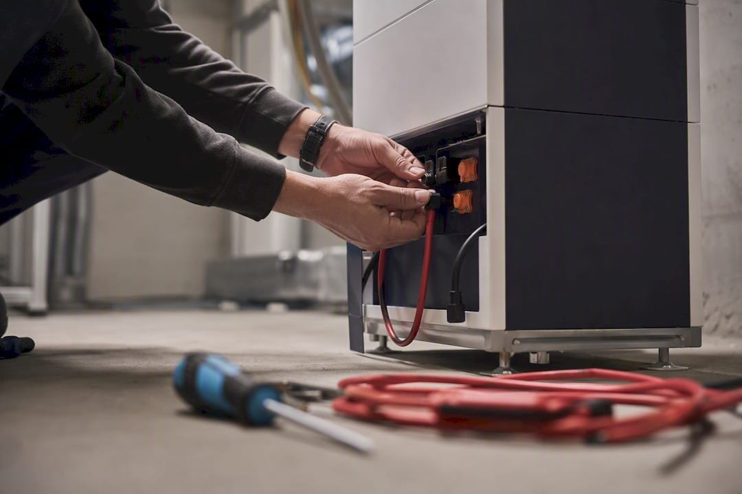 Handen die een thuisbatterijsysteem aansluiten