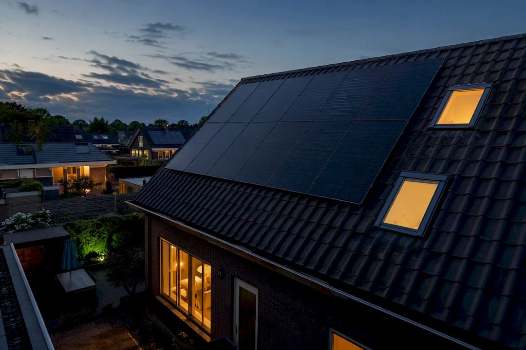 Nederlandse woonwijk met zonnepanelen in het avondlicht
