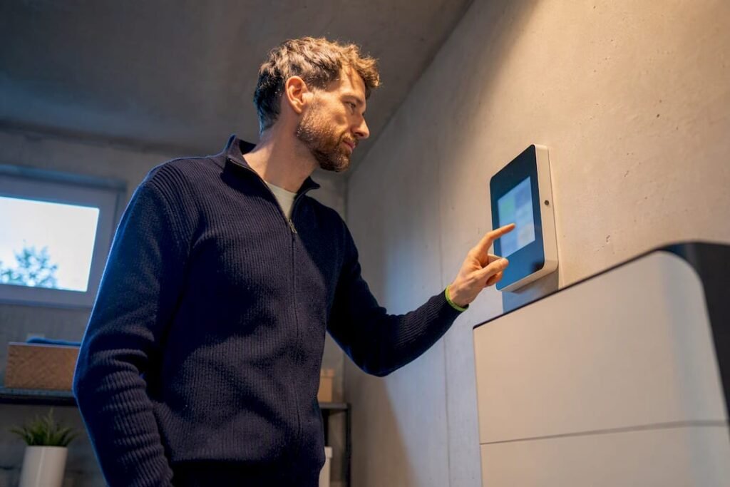Huiseigenaar kijkt naar energiemeter naast batterij